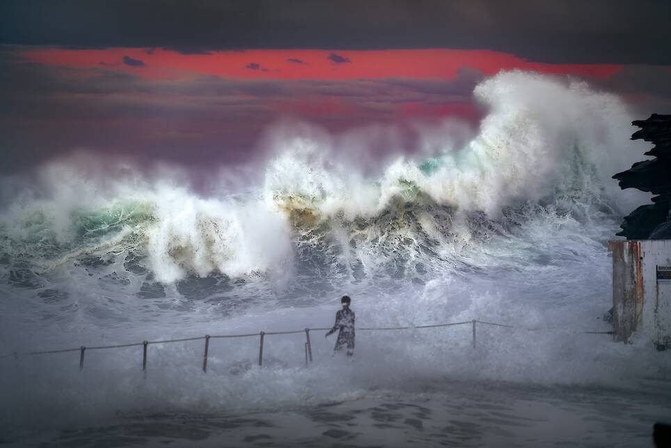 Gergo Rugli. A teenager stands at Bronte Ocean Pool, Sydney, as a powerful swell sends waves crashing over the closed bathing site