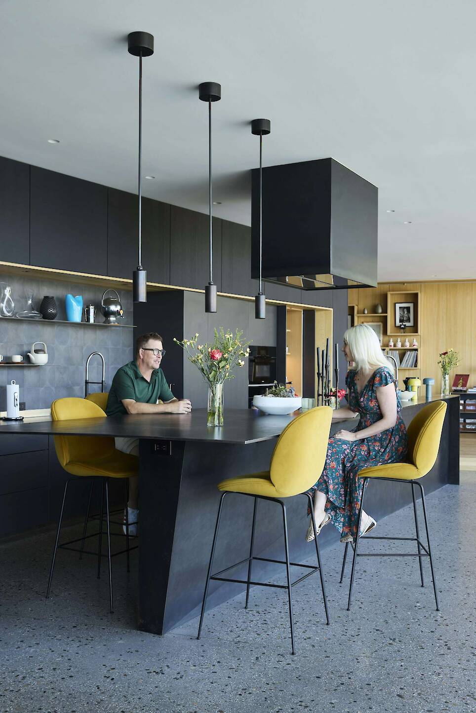 Beetle bar chairs by Gubi pull up to a custom blackened-steel island by Chris Conant and Conant Moran in the kitchen, which features Bulthaup built-ins and Apparatus pendant lig