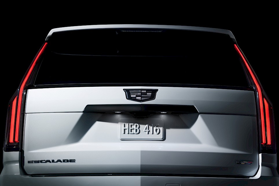 Rear view of a silver Cadillac Escalade-V 125th Anniversary showing the taillights, brand emblem, and license plate reading HEB 416
