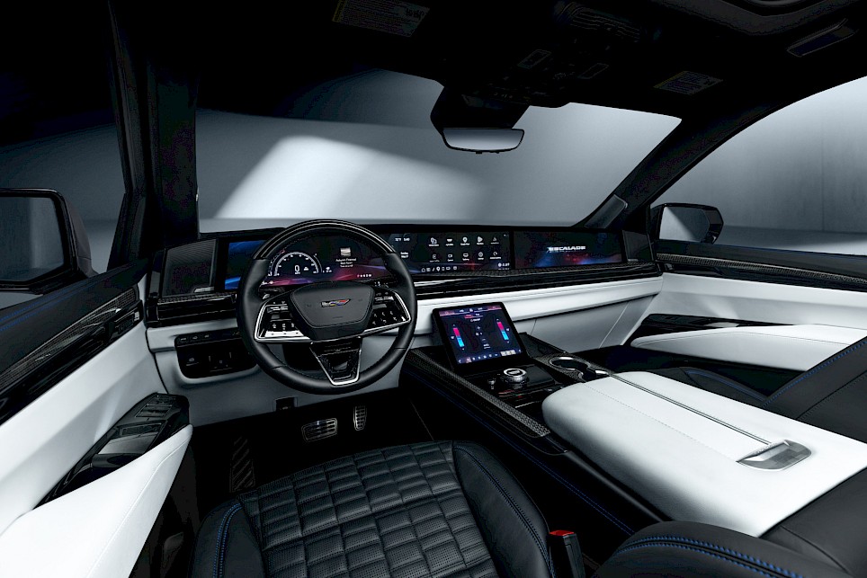 Interior of a Cadillac Escalade-V 125th Anniversary featuring a curved dashboard display, steering wheel, and black and white leather seating