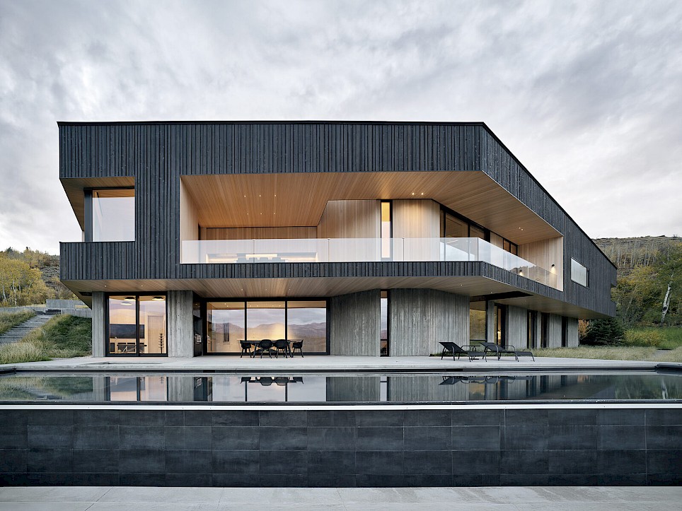 CLB Architects’ Boomerang Residence curves around a hillside courtyard, balancing expansive mountain views with more intimate spaces